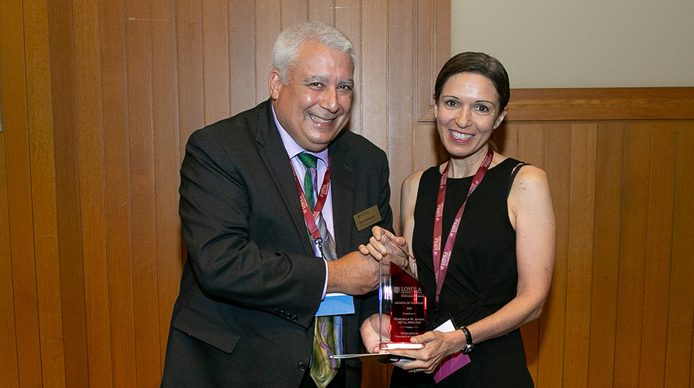 Dean Sam J Marzo presents the 2025 Excellence in Research and Innovation award to Marcella M Alsan, MD, MPH, PhD, MD 05.