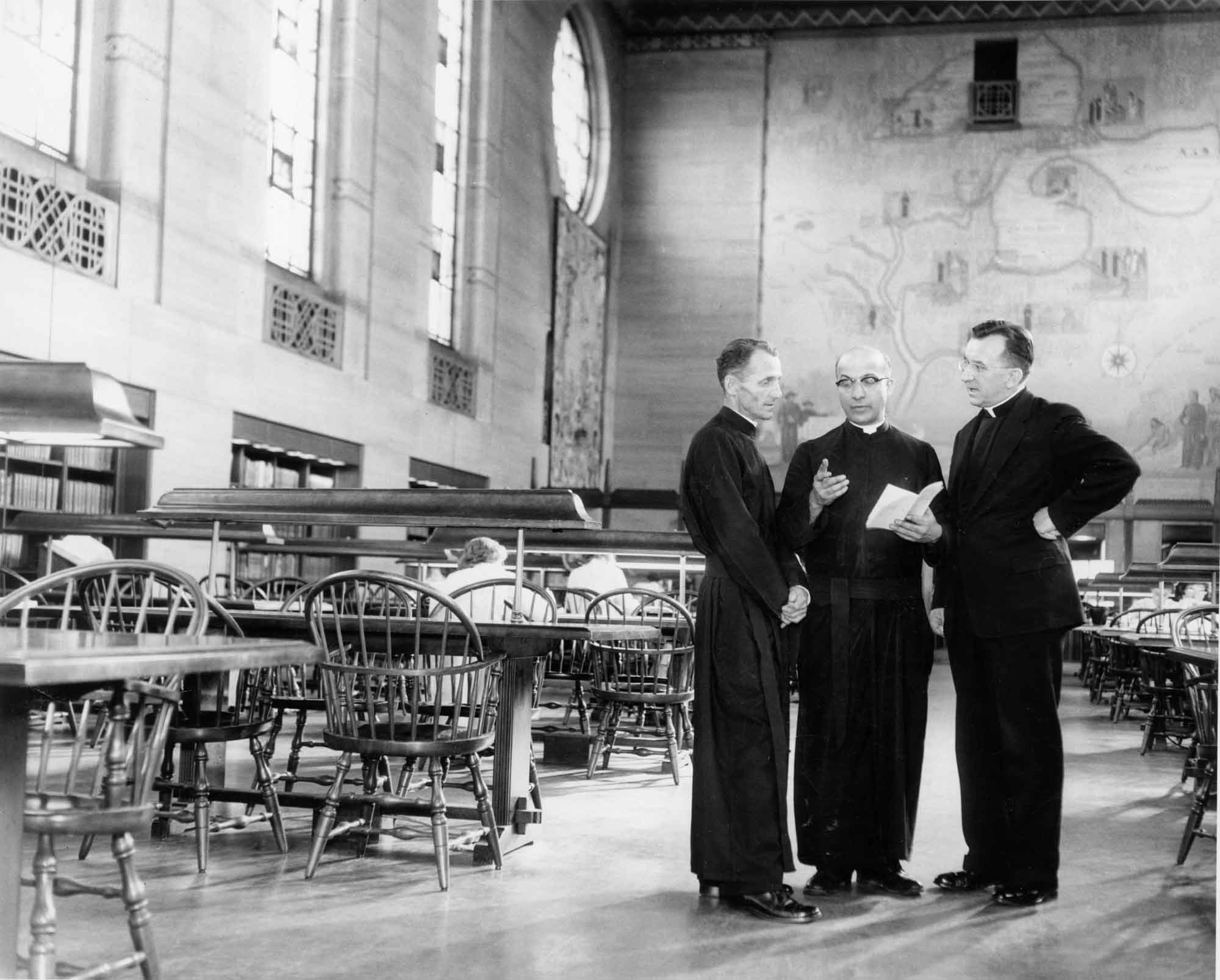 Three Jesuits in the Cudahy Library reading room.