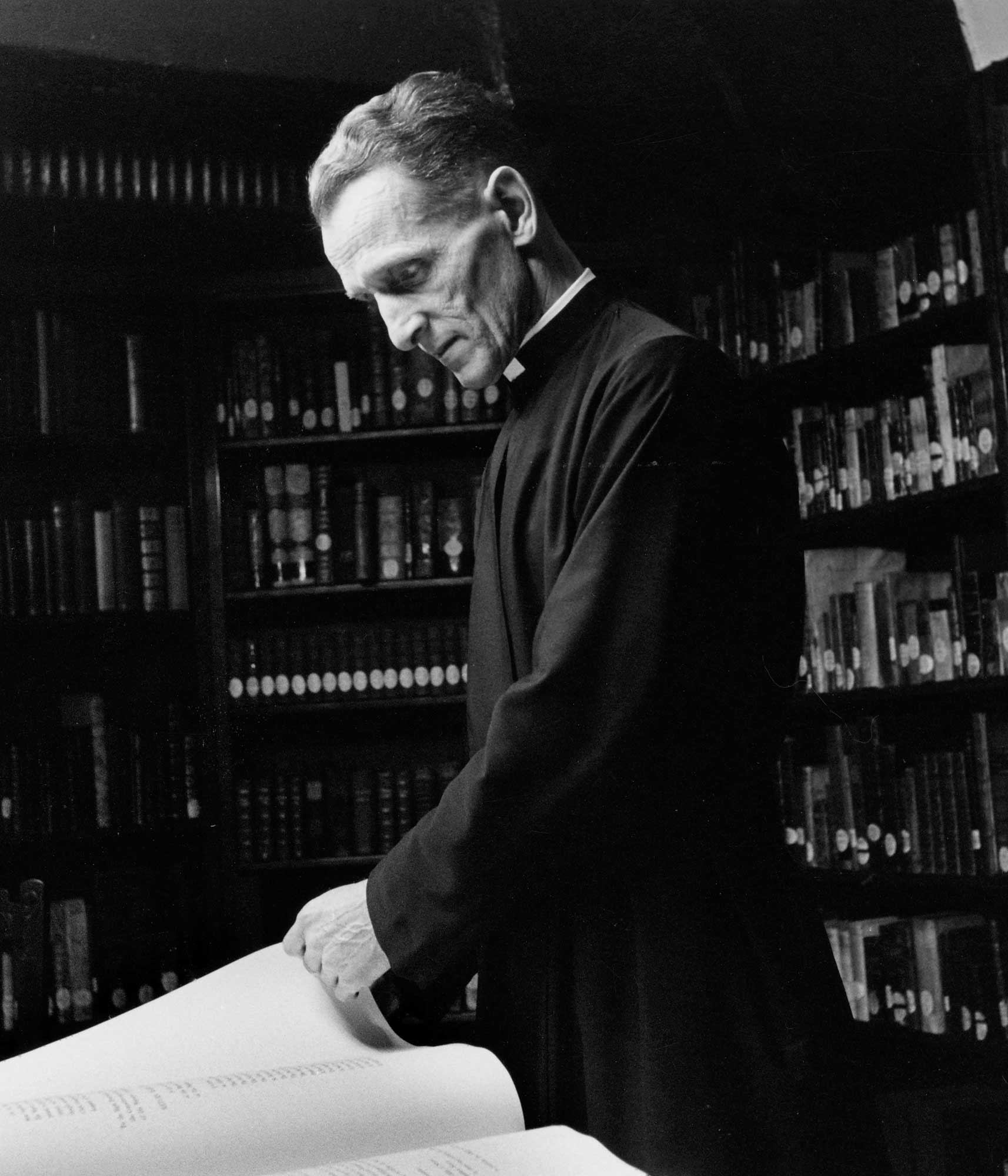 Edward I. Surtz, S.J., looks at a book