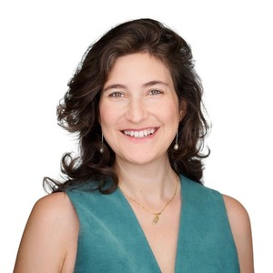 headshot of a person in blue shirt in front of a white backdrop