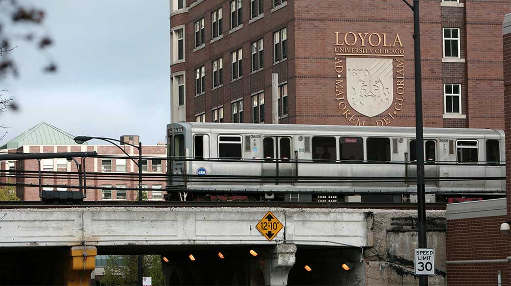 Chicago L train passes by Loyola University Chicago campus on overhead tracks