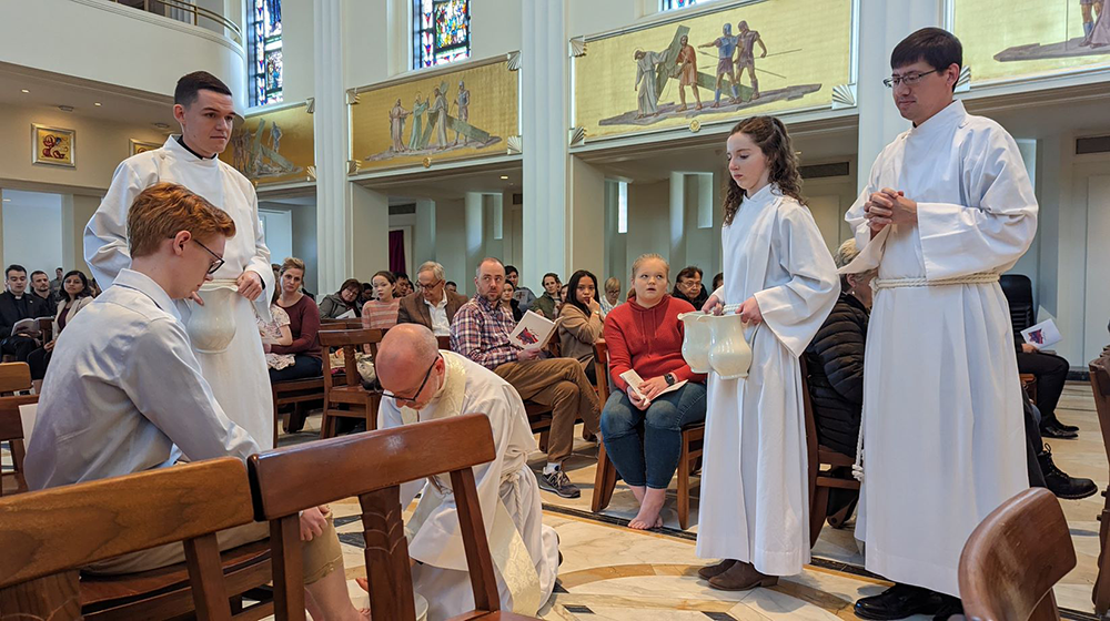 An altar server getting their feet washed by a Priest