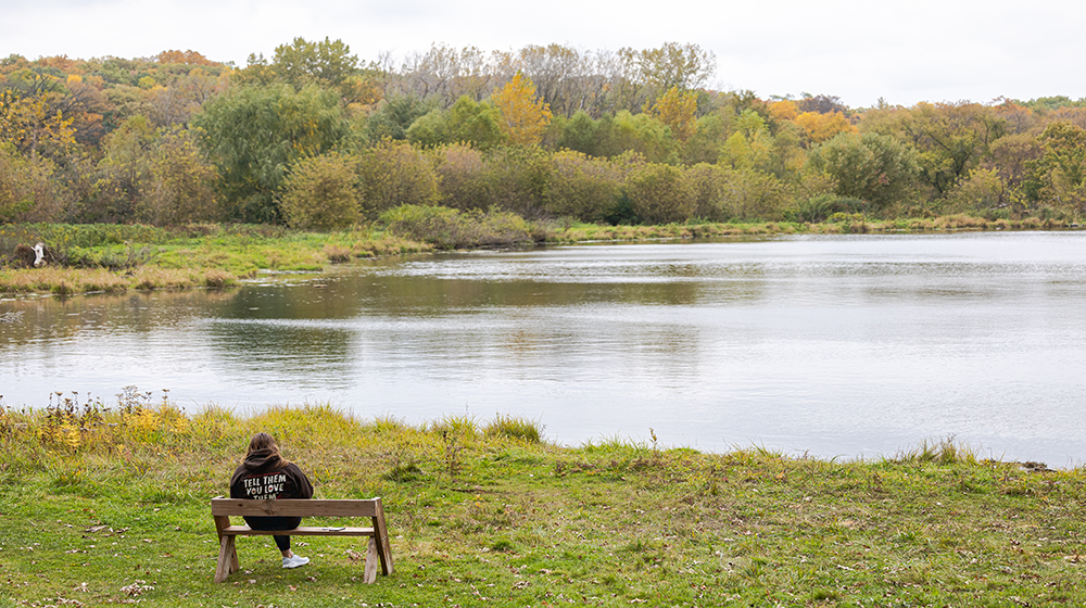 Student sitting by the lake