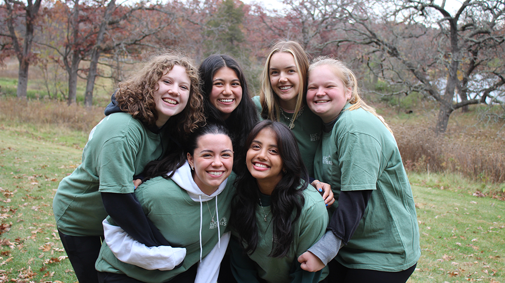 Six students embracing each other, smiling