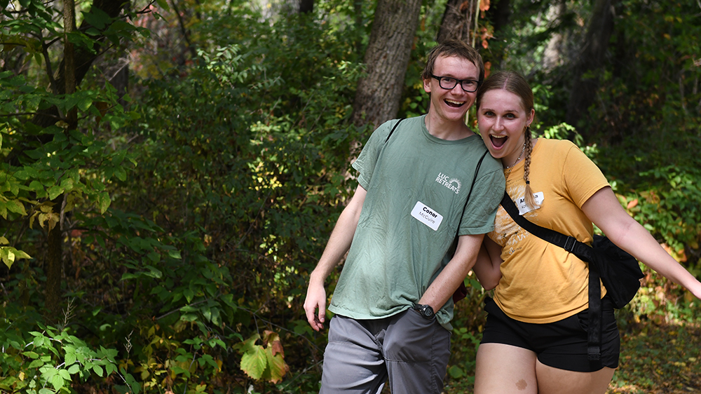 Two students smiling in the woods