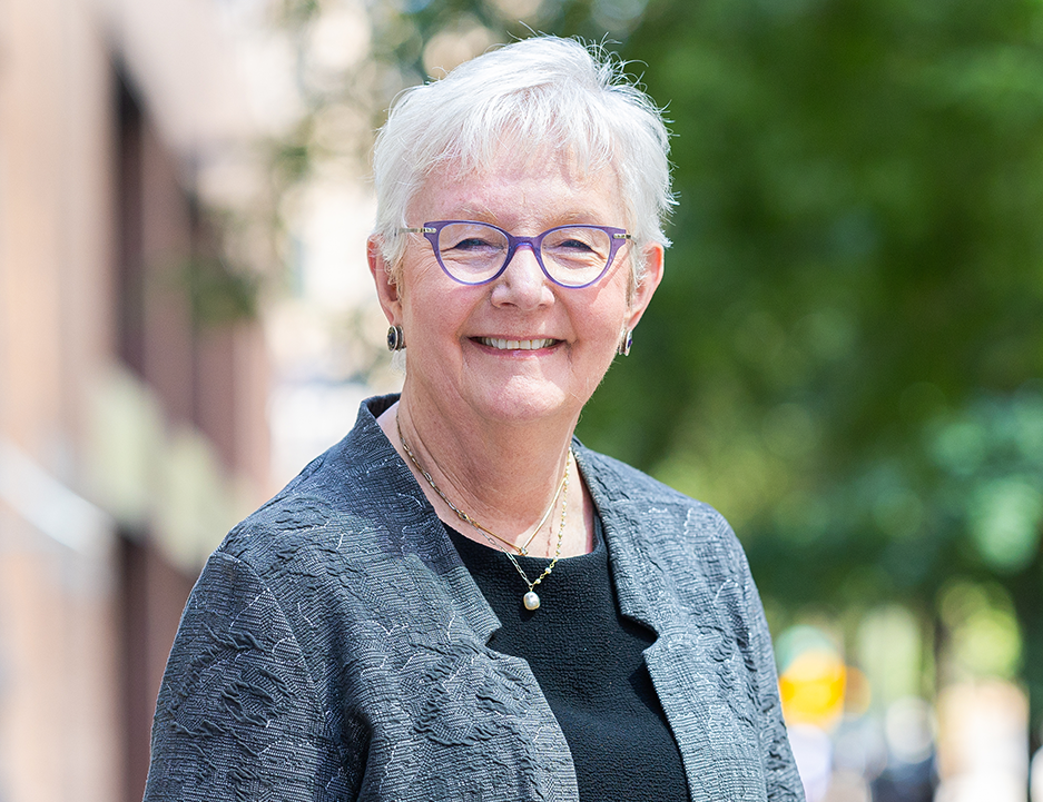 Chief Justice Mary Jane Theis smiles in front of an urban background
