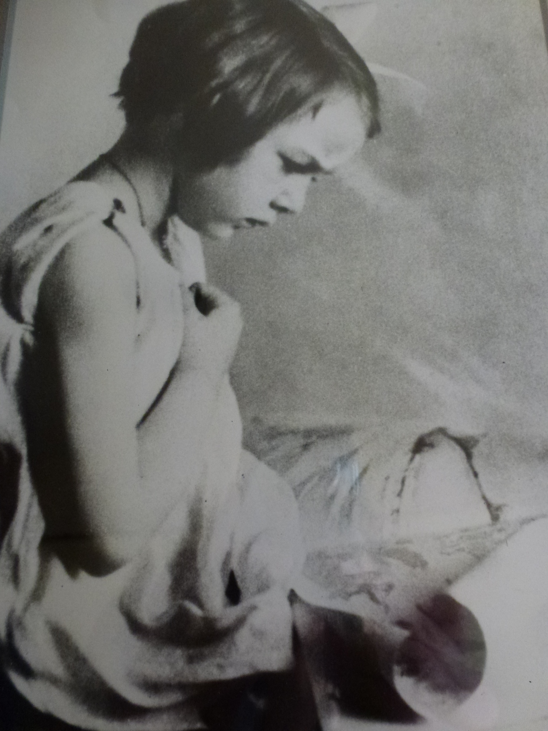 Black-and-white childhood portrait of three-year-old Flannery O’Connor reading, seated in profile