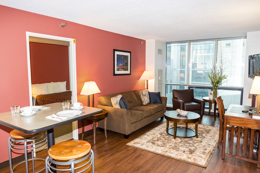 Empty hotel living room with a kitchen table and furnishings