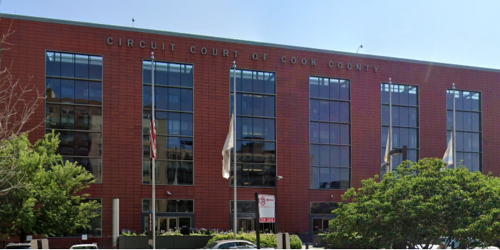 Exterior of the Circuit Court of Cook County building with flags and trees in front.