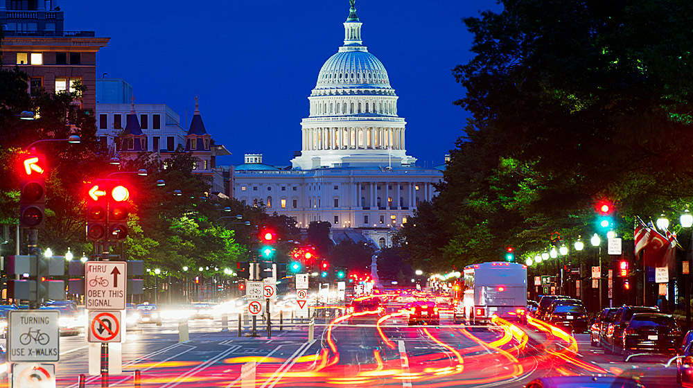 An image of United States' Capitol at night with traffic