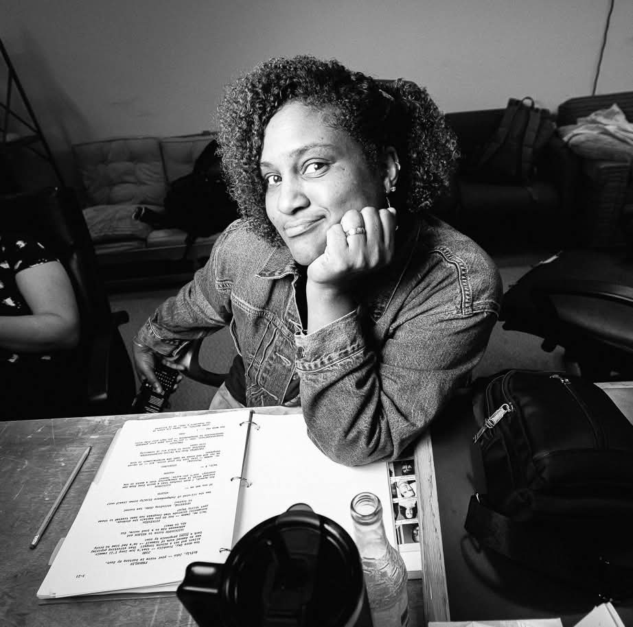 Tanji Harper sits at her desk resting her head on her shoulder.