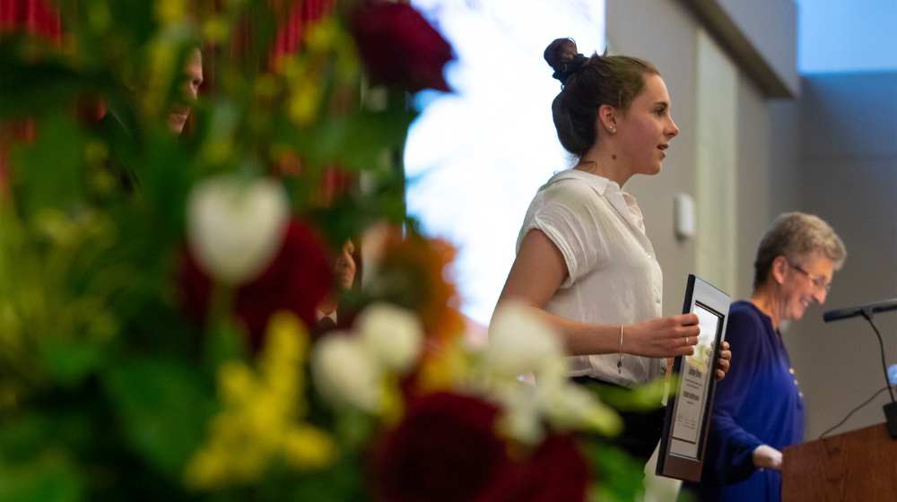 A student stands with their award.