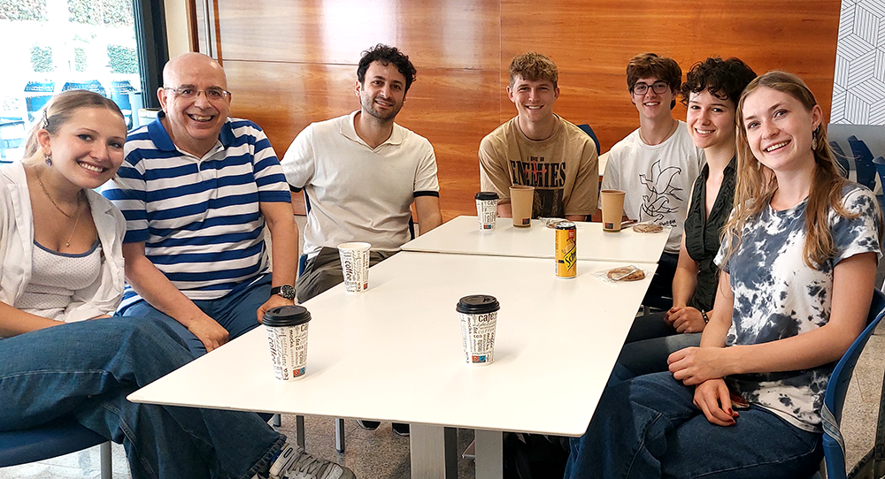 Students sitting at a table with a faculty mentor.