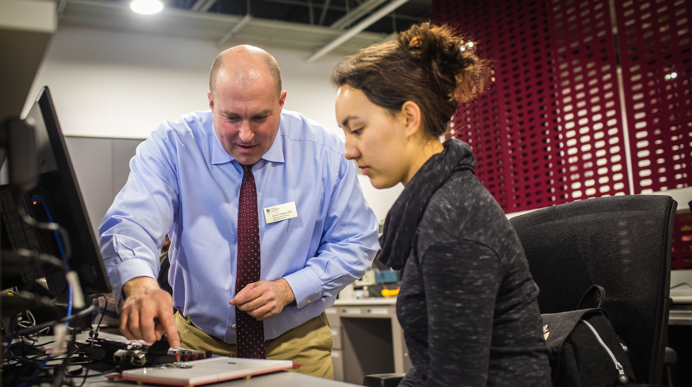 Engineering faculty instructing a student.