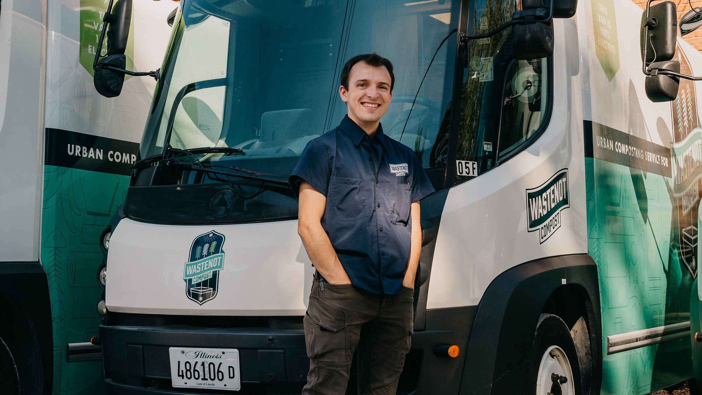 Liam Donnelly in front of compost trucks from the company he founded