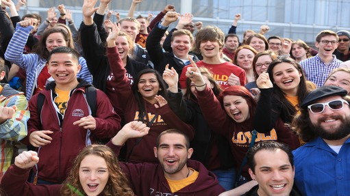 A group of students in maroon and gold apparel cheer.