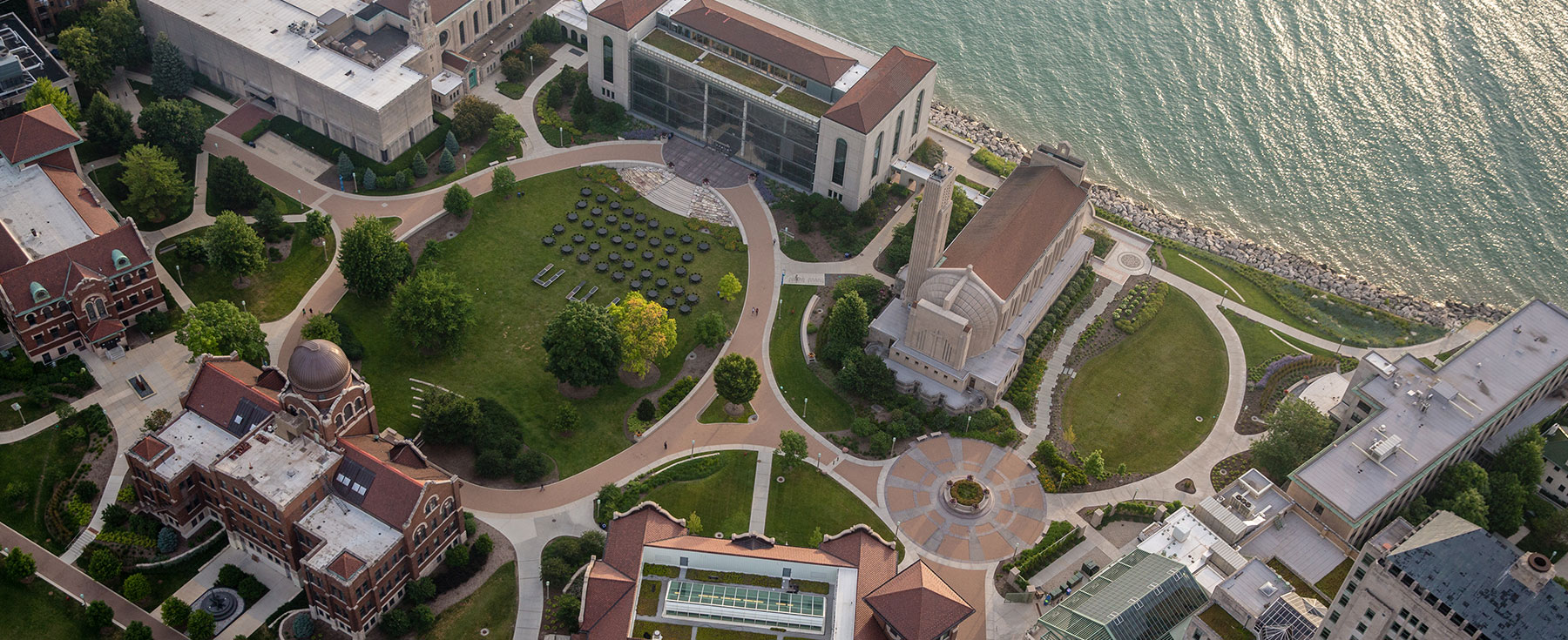 Aerial view of a university campus with buildings, green spaces, and a lakeshore