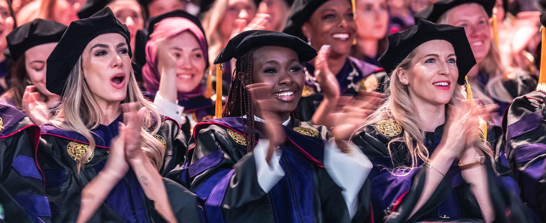 Three students applauding during commencement