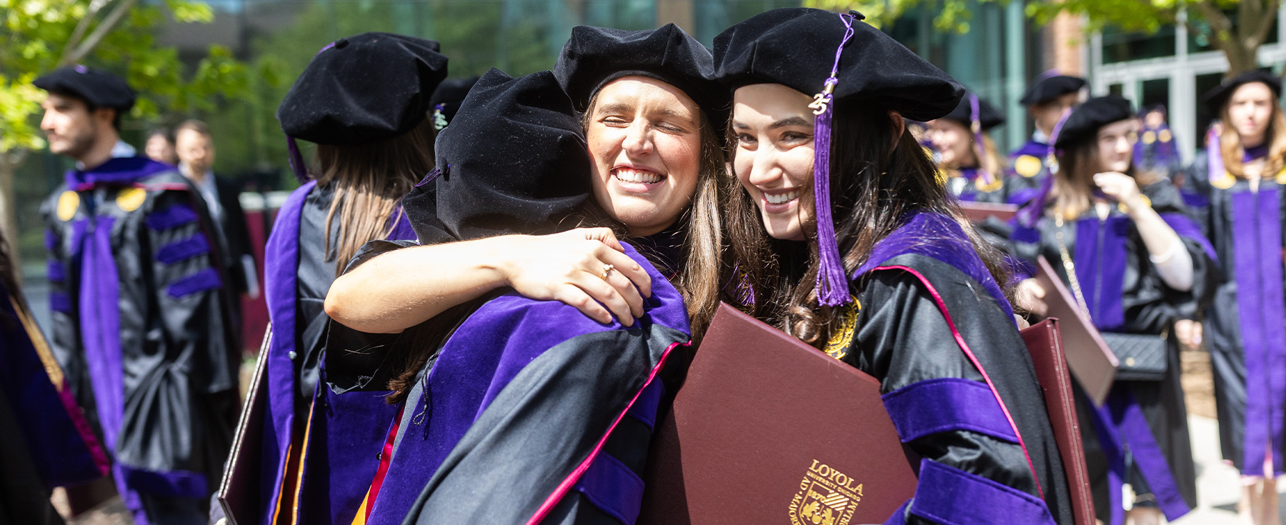 Three students celebrating post-commencement