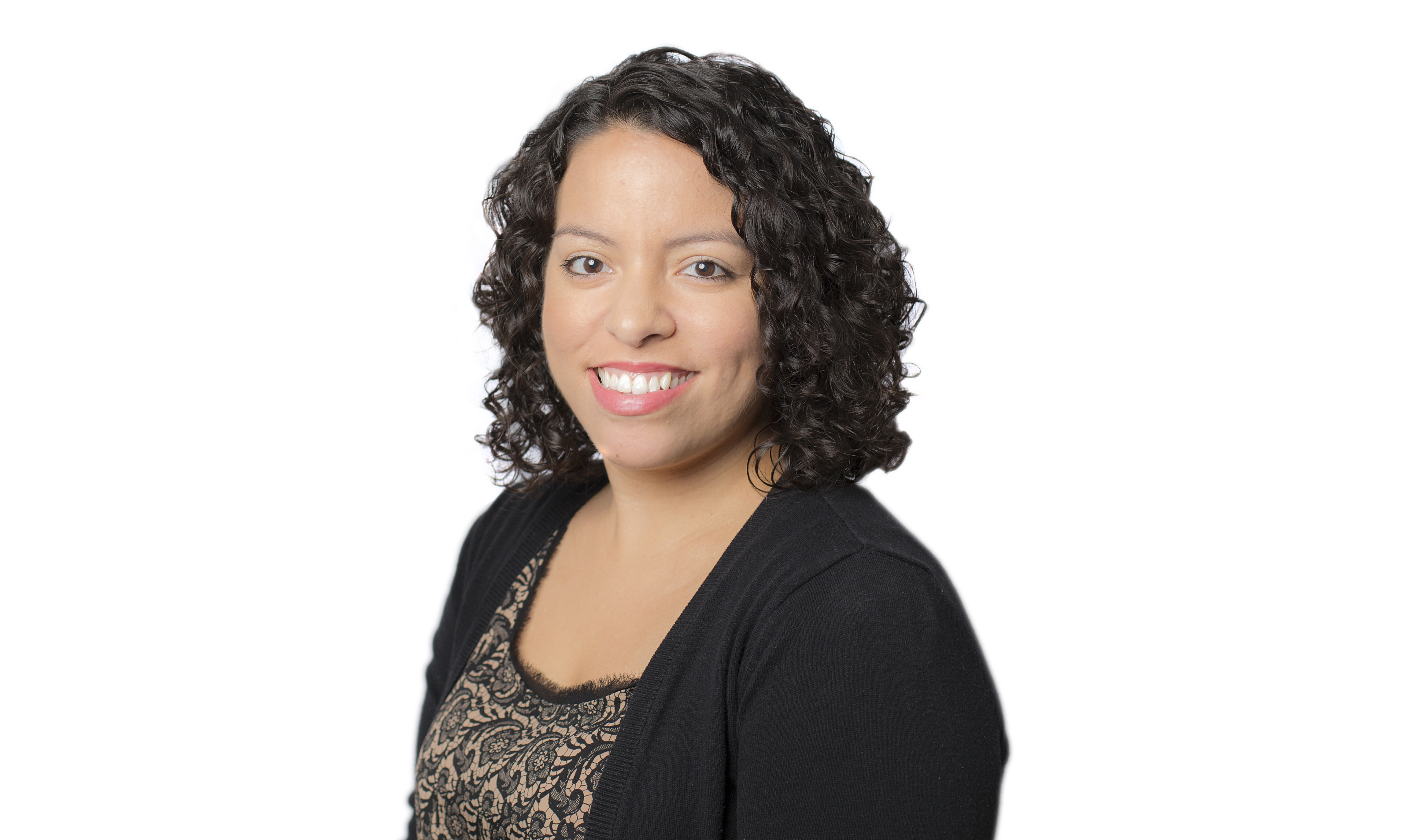 A woman with curly dark hair smiling.