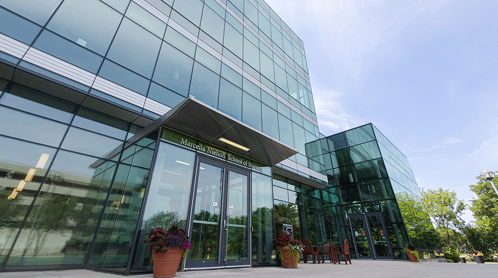 The Marcella Niehoff School of Nursing sign above the entrance of the school's glass exterior building at the Health Sciences Campus on a sunny day