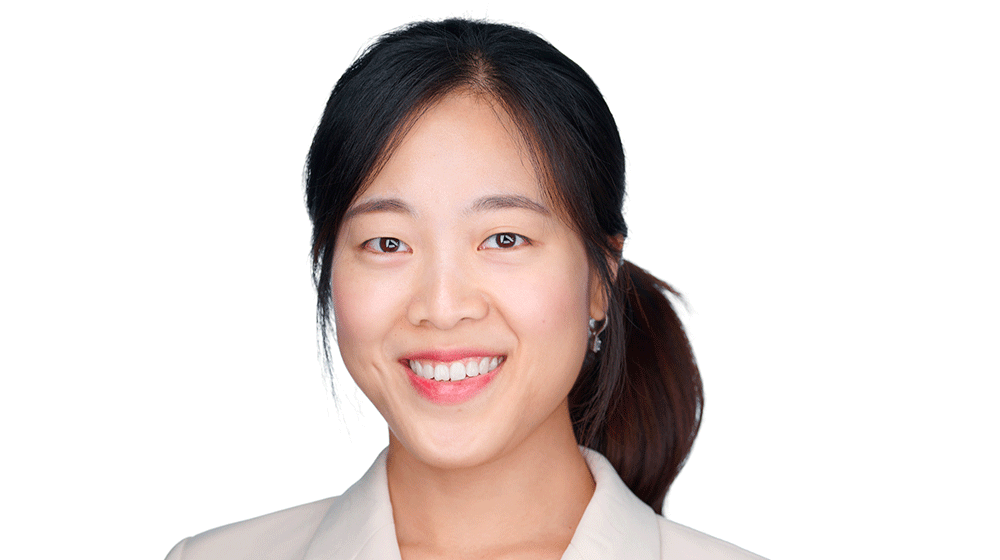 Headshot of Sueyeon Lee, smiling and wearing an off-white blazer