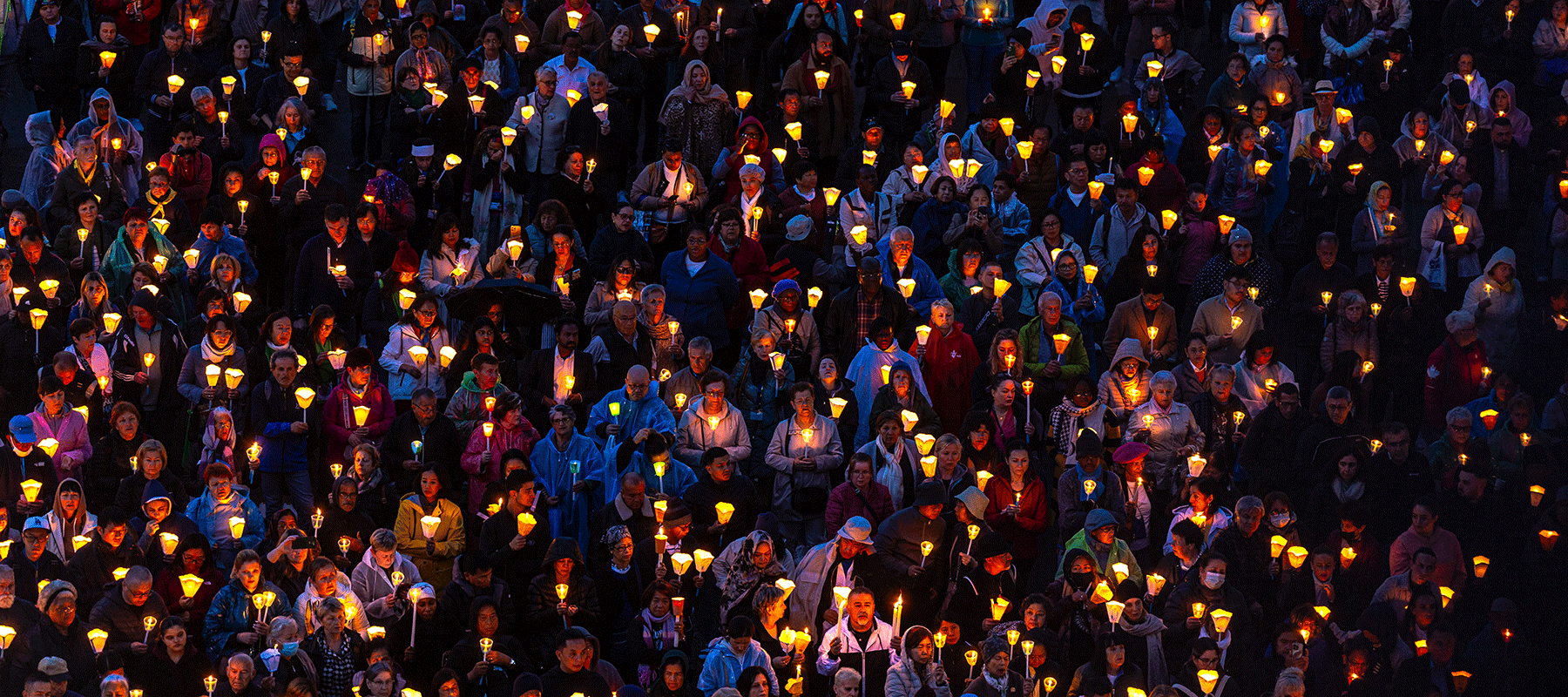 Lit candles of different colors burn