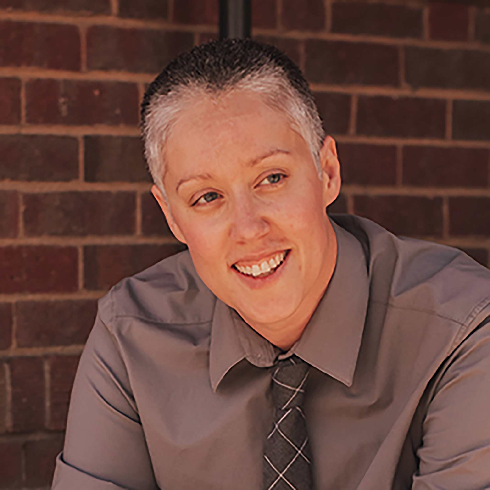 Lindsay Lennox smiling in front of a brick wall