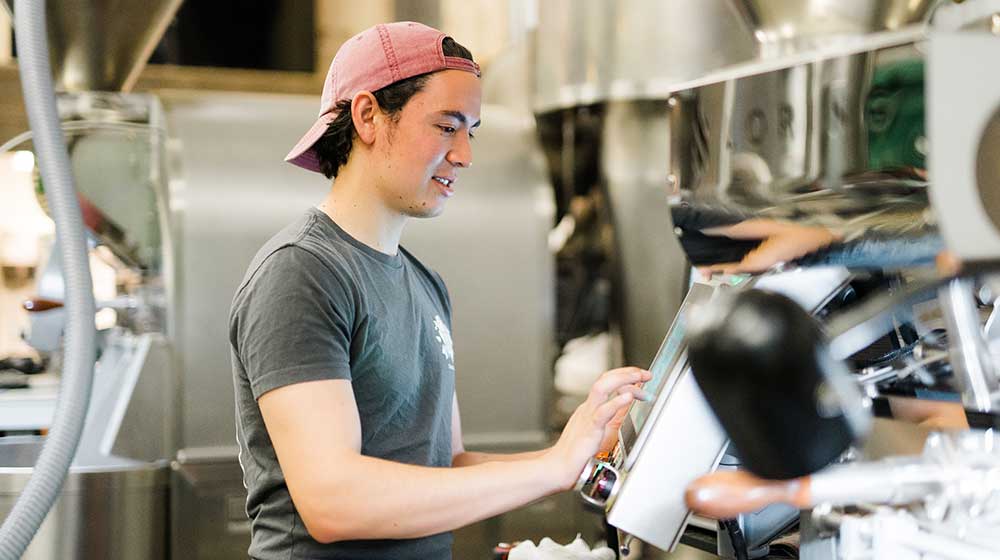 Image of Harry Hutchins next to his coffee roaster