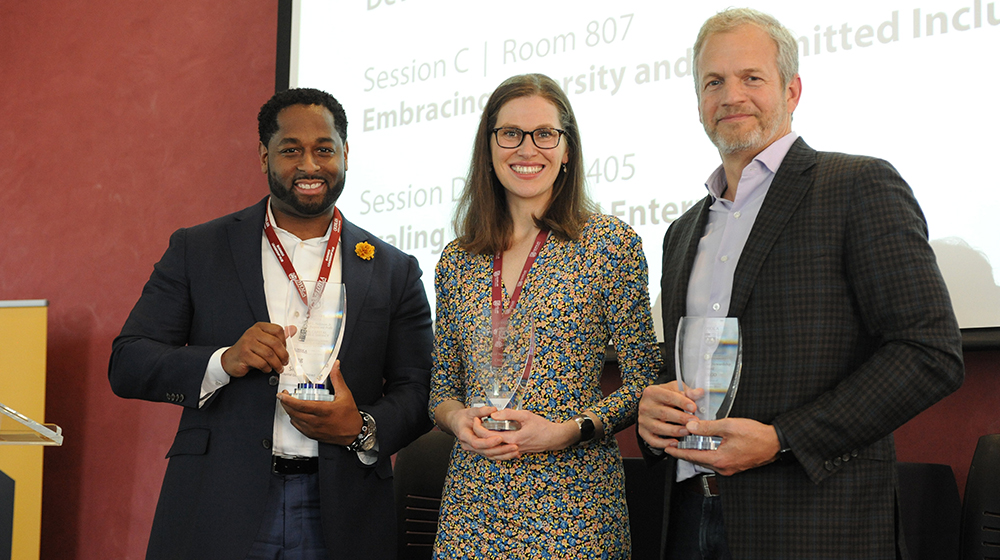 Representatives from Chobani, Bain Capital Double Impact, and Indigo Ag holding glass awards.