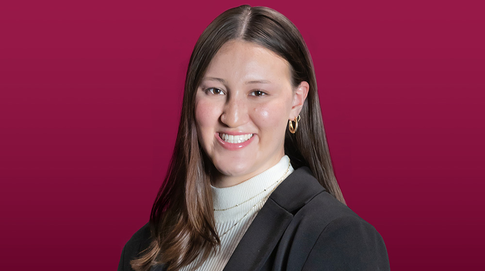 Headshot of Jillian Cole on a maroon background