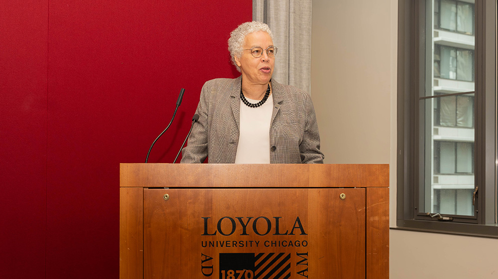 Toni Preckwinkle delivers a speech behind a podium reading 