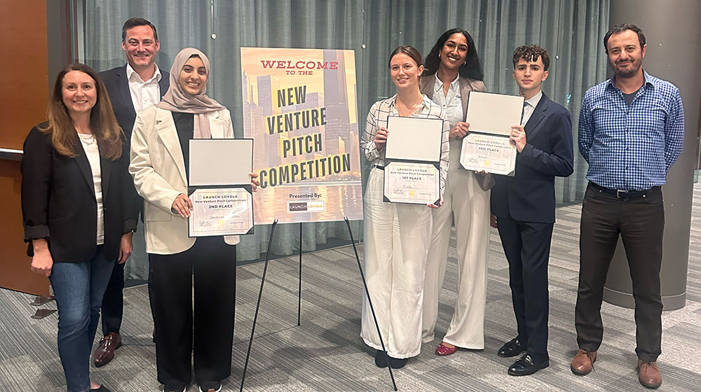 The winners of the 2024 New Venture Pitch Competition stand by a sign reading 