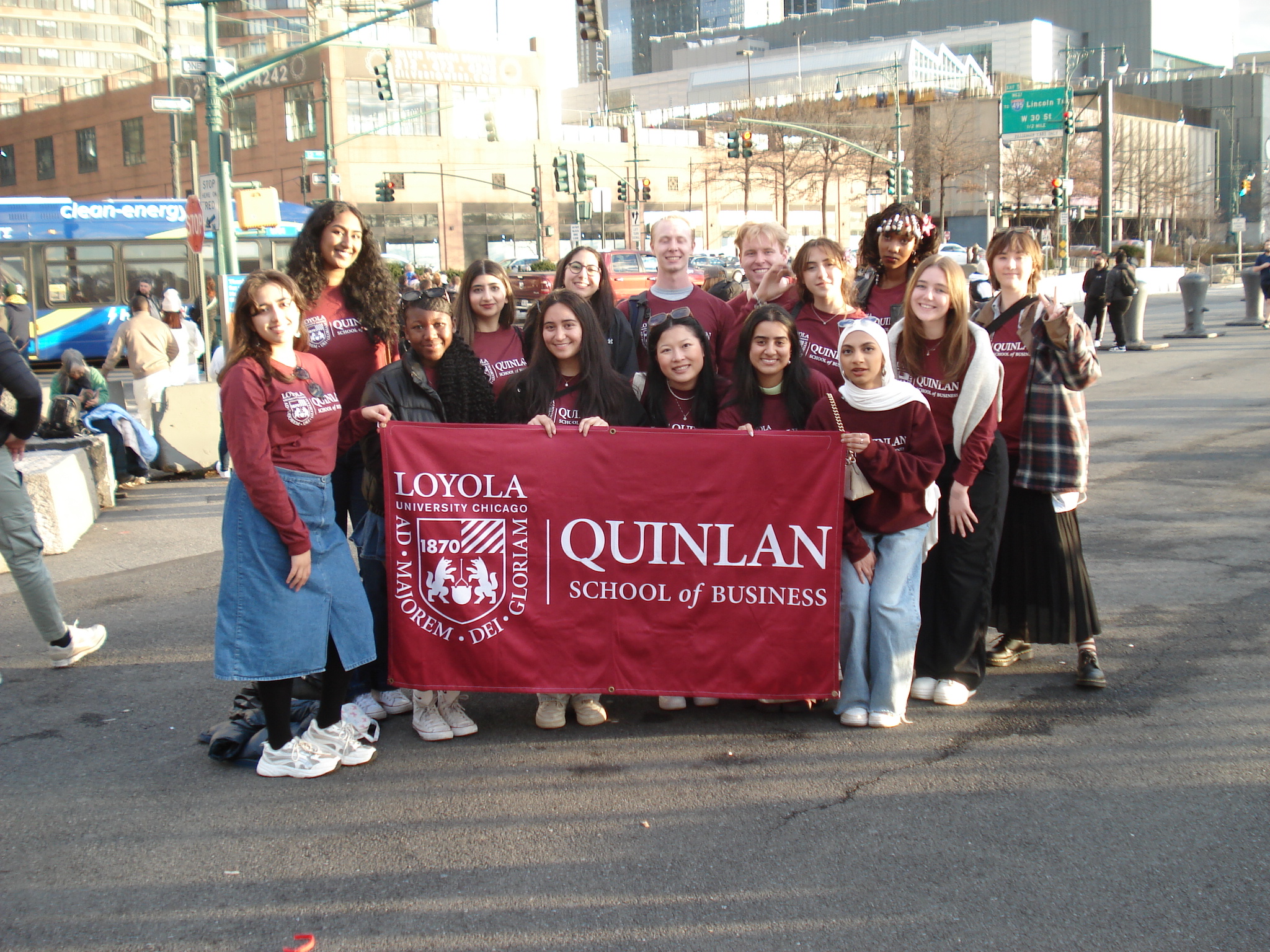 The Quinlan Ramble to New York students pose for a group photo with the maroon Quinlan banner.
