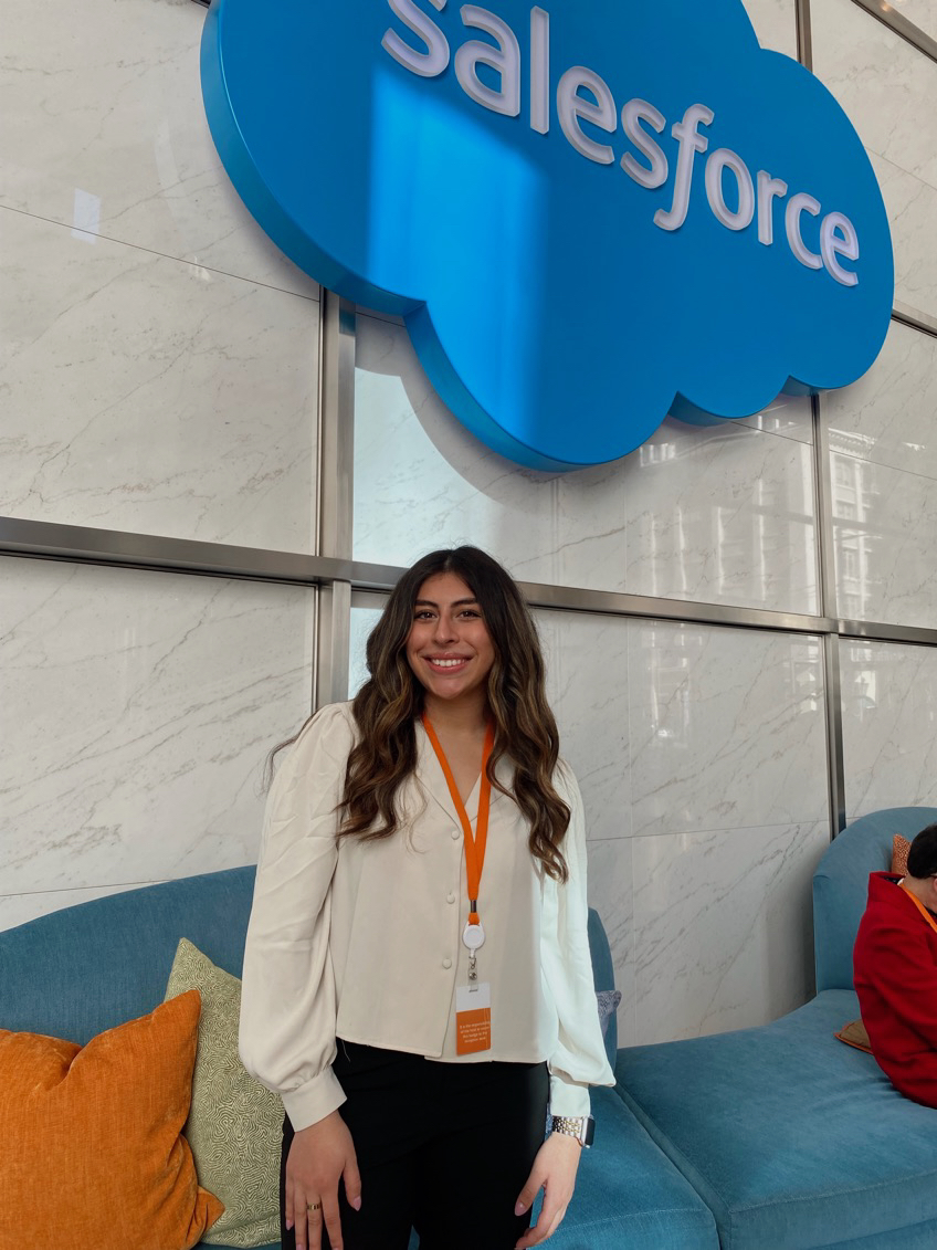 A student in front of the Salesforce sign in Salesforce Tower in San Francisco, California.
