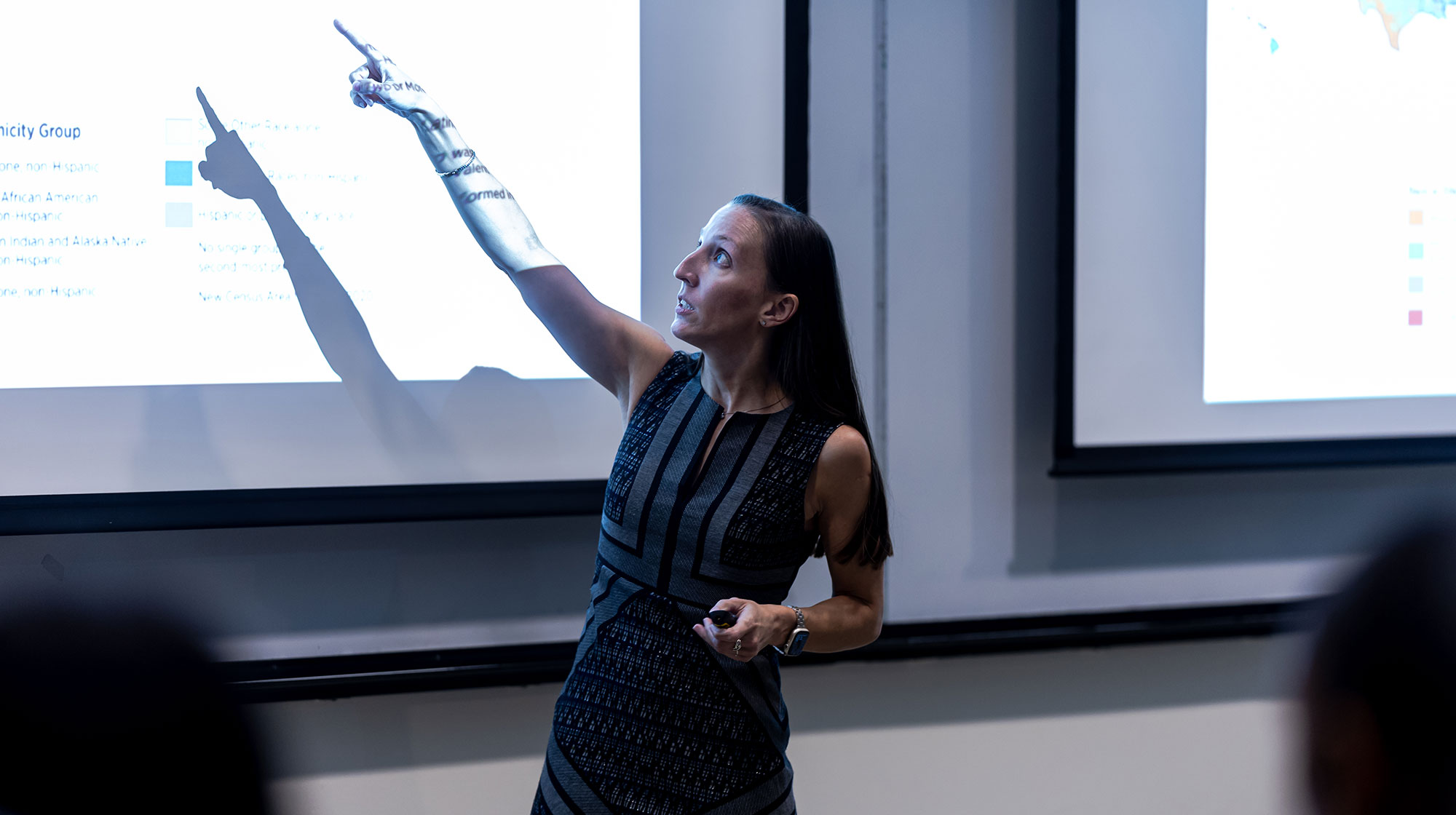 Brittany Bauer points to the projection on the wall in her class as she speaks to the unseen students attending