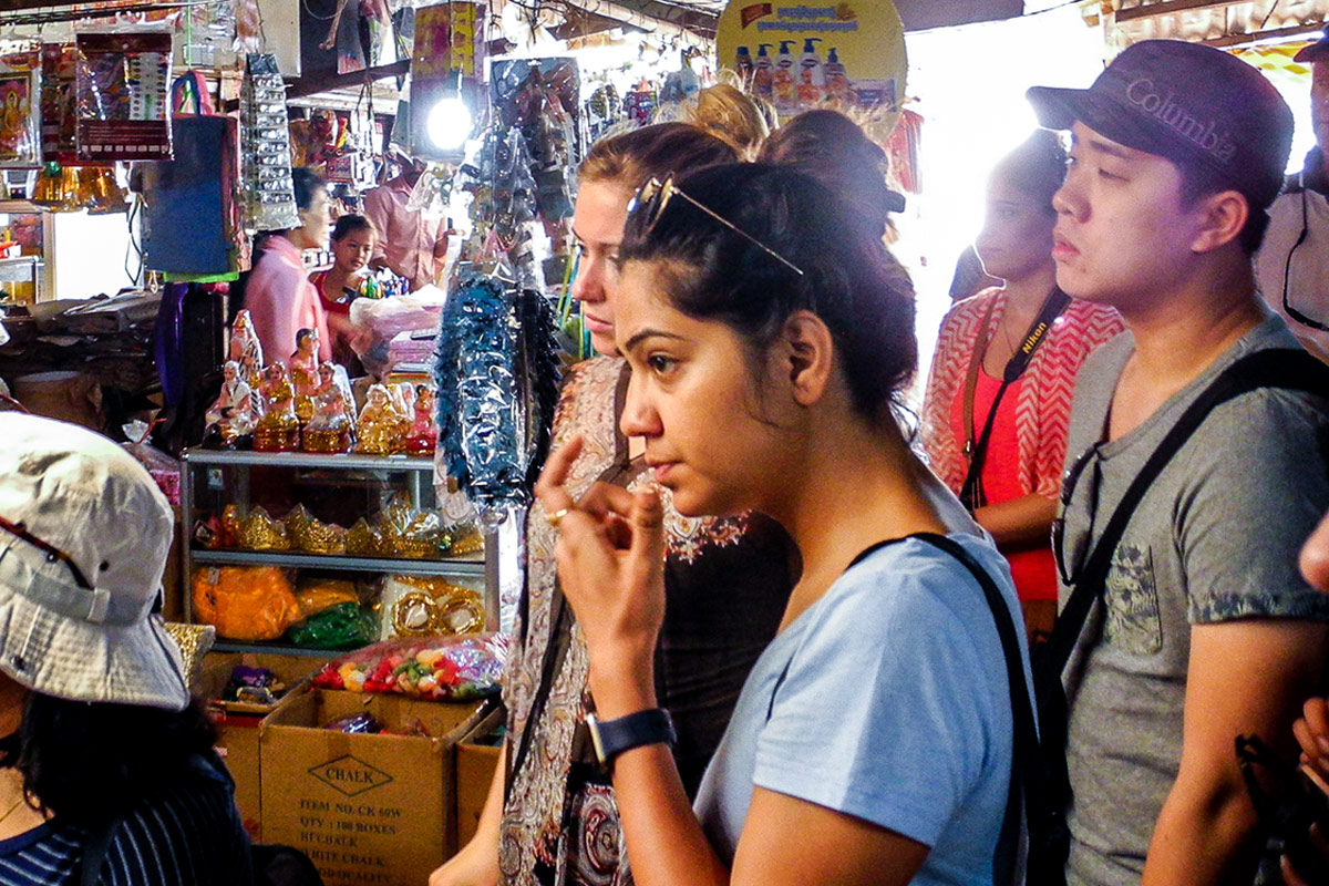 Several people stand in a very small shop in Cambodia