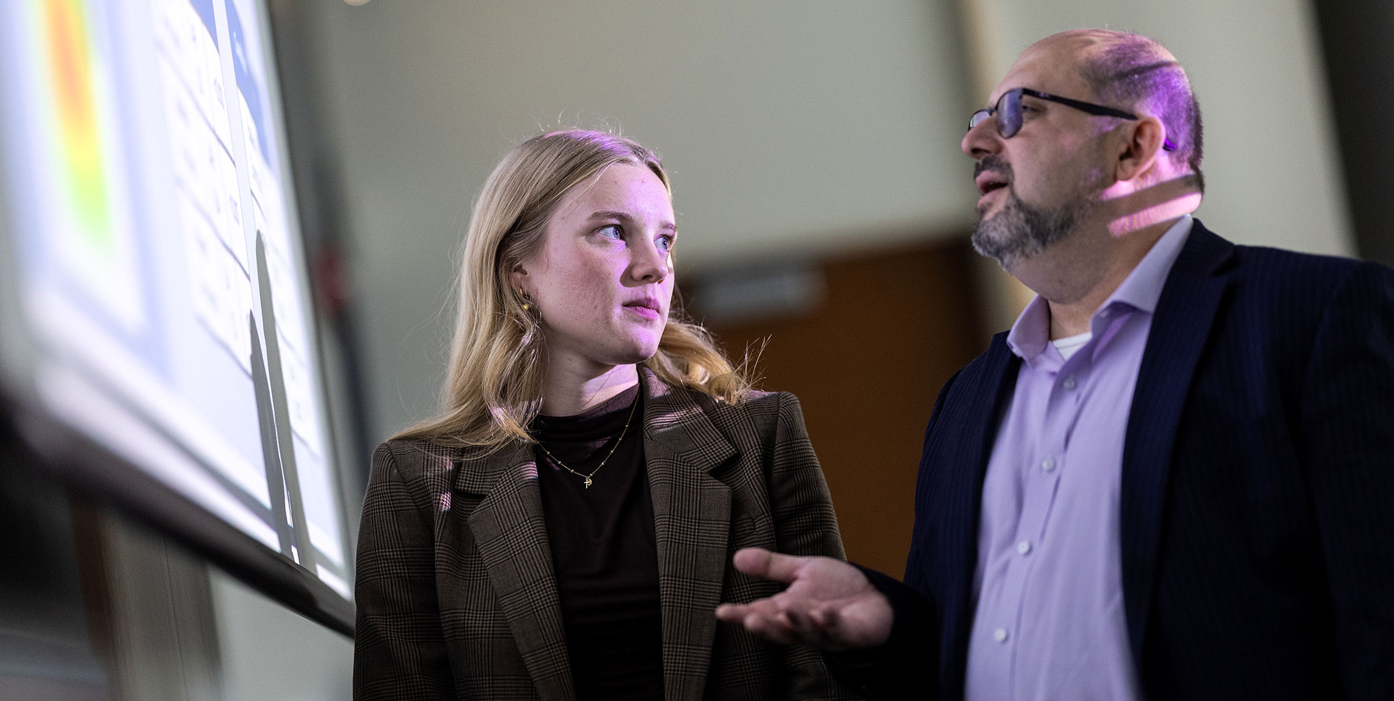 Angelika Tokarczyk (BBA ’25) (left) and Dinko Bačić, associate professor of information systems and director of the UX and Biometrics Lab, discuss data insights.