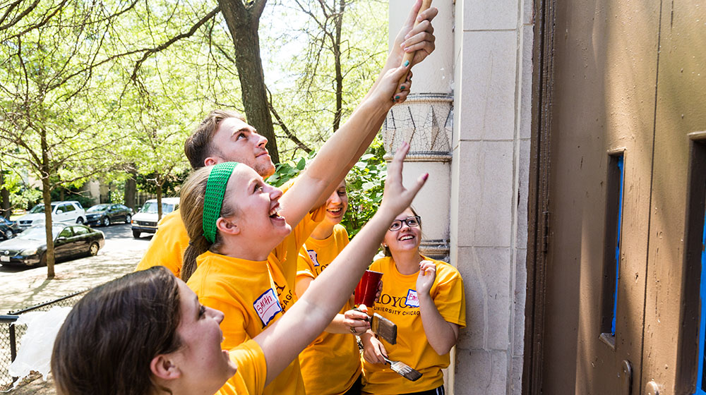 A group of volunteers wearing yellow shirts and smiling.