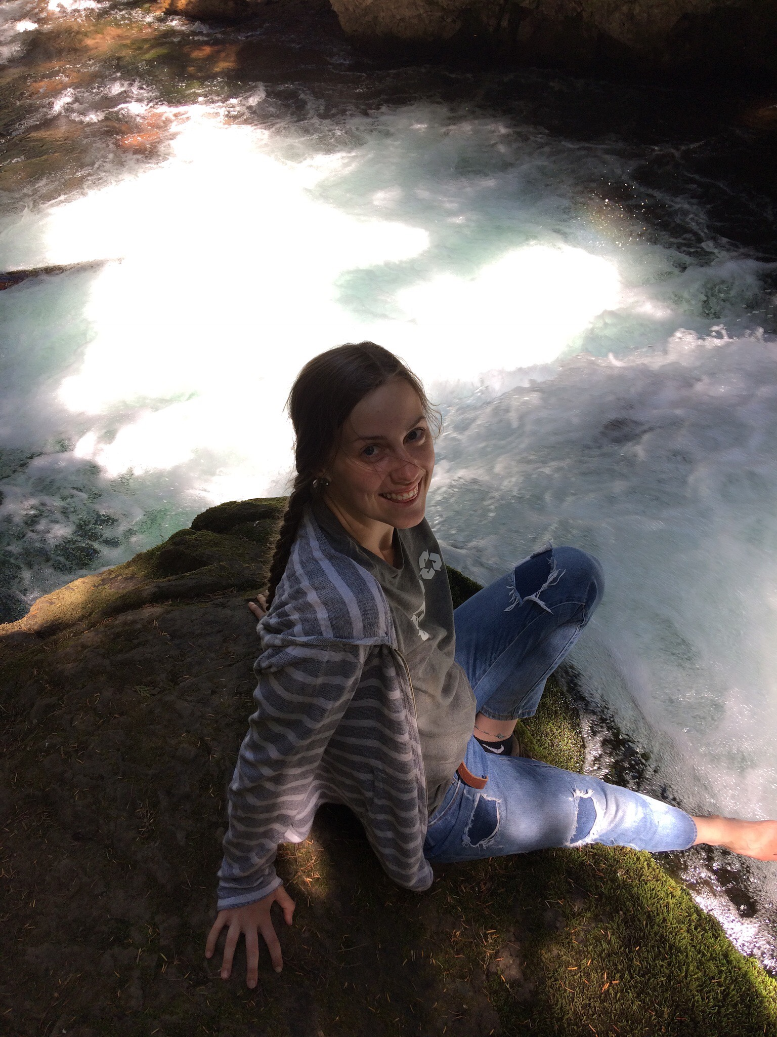 Cami Provencher sitting on a rock by a stream