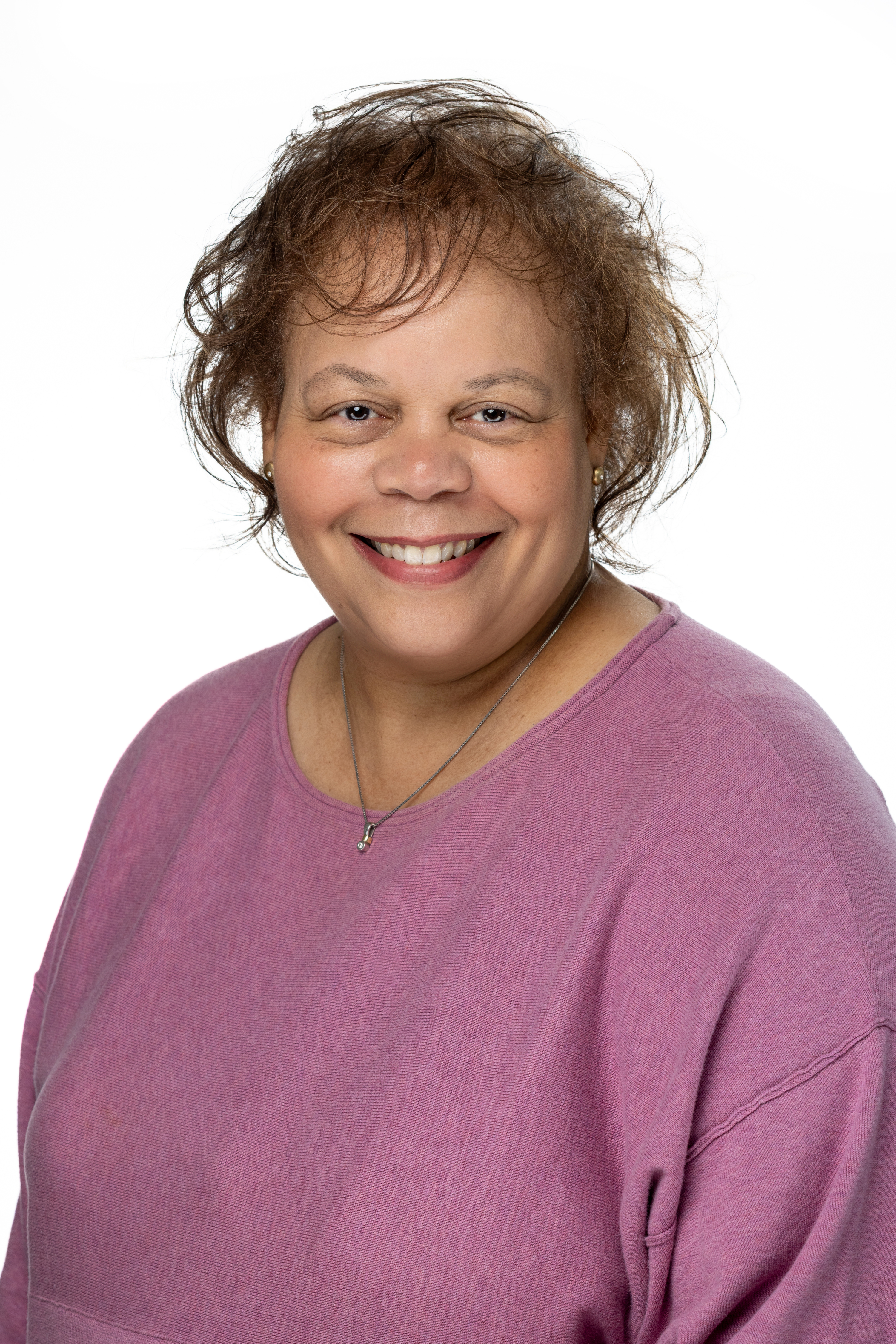 Portrait of Stephanie L. Chapman, Assistant Dean for Administration in the School of Social Work, smiling and wearing a mauve top against a light background.
