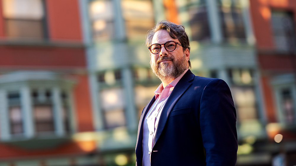 Professor Jonathan Singer, Ph.D. stands downtown Chicago on a Fall day