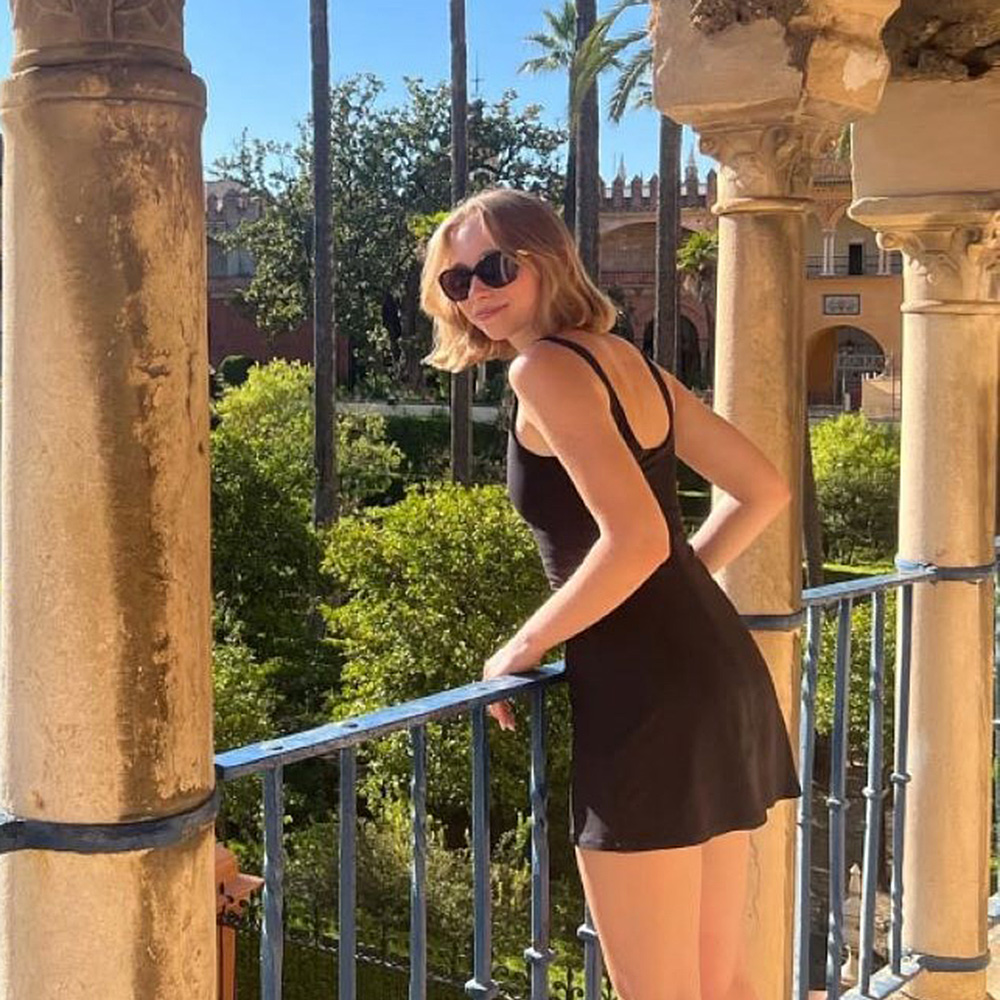Yeva Bilenetska smiles near a balcony overlooking a garden below.