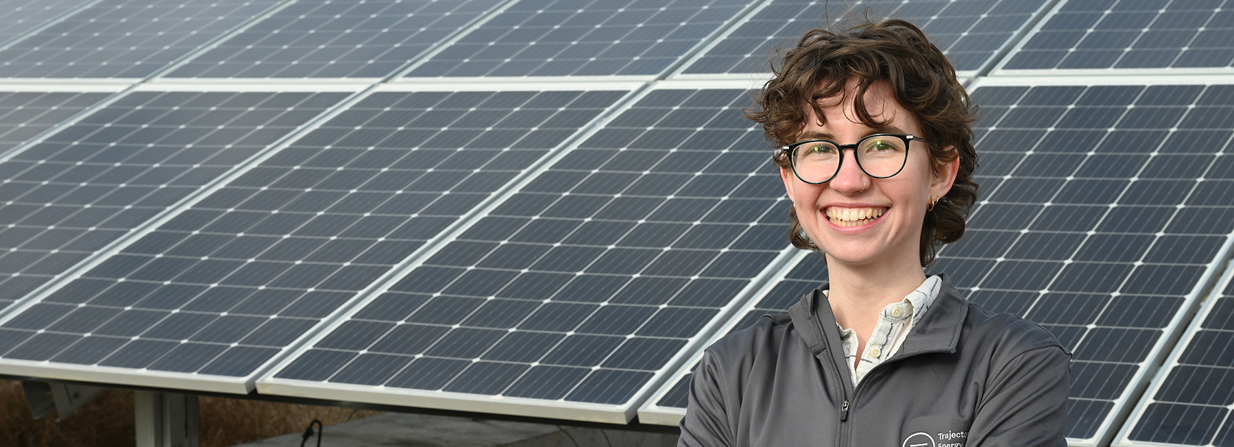 alum Emily Hammermeister standing in front of solar panels