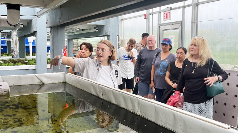 Bailey Uttich leads a tour of an aquaponics facility