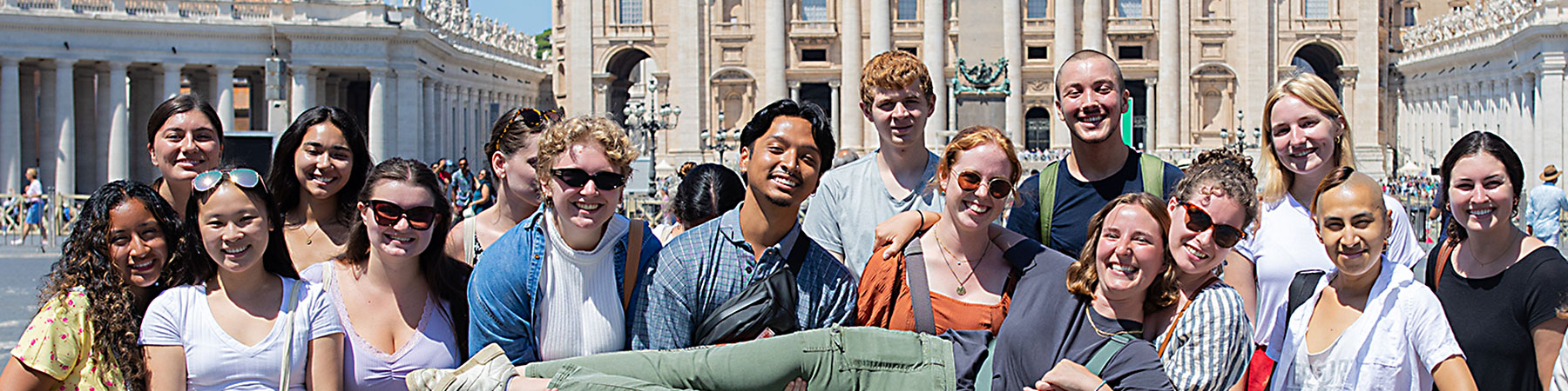 A group of students in Rome gathered on a plaza for a group photo