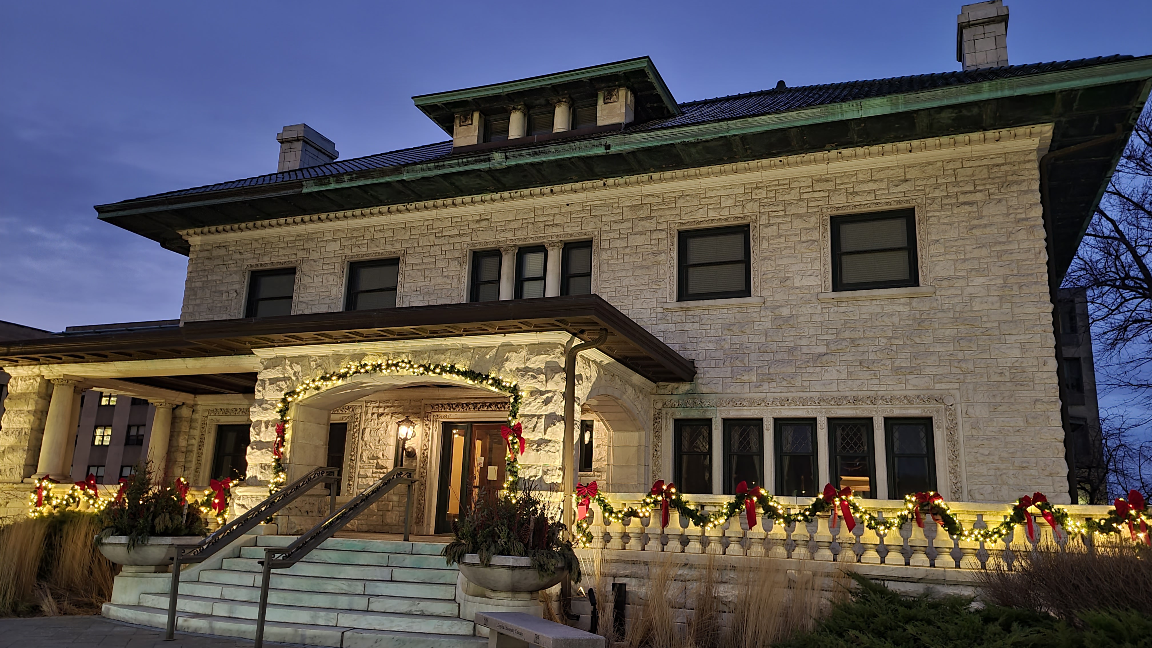 View of Piper Hall from south entrance. The building is decorated with Christmas lights and bows.