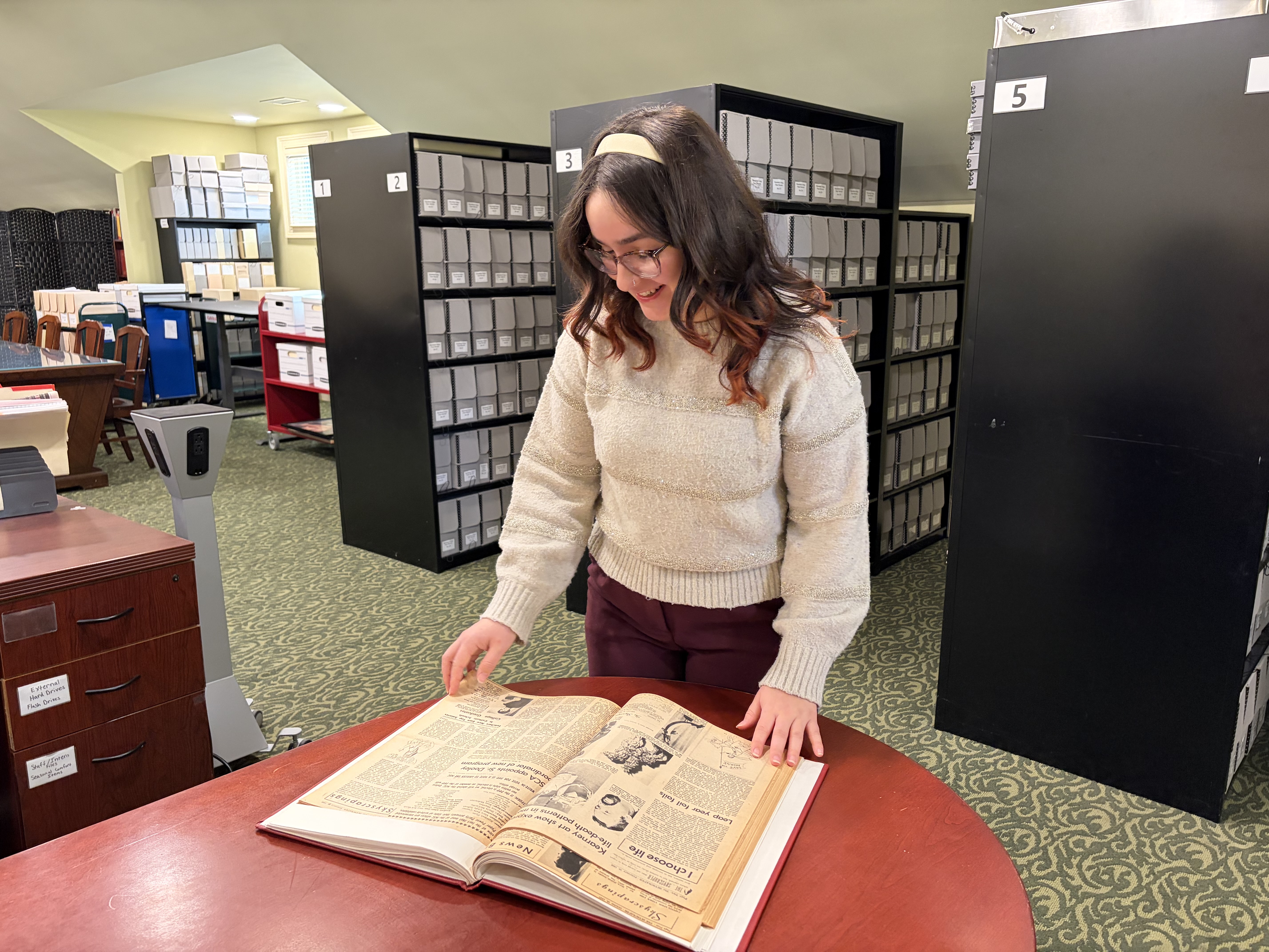 Student looking at bound newspaper