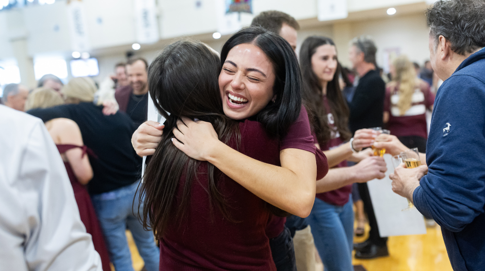 Athena Barrett shares a joyful hug with a classmate at Match Day celebration