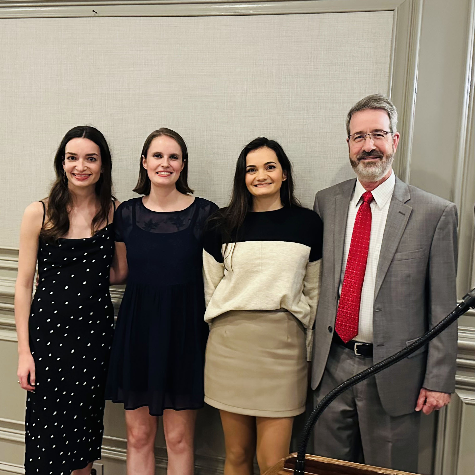Three students who are competition winners standing next to Mitchell Denning, PhD